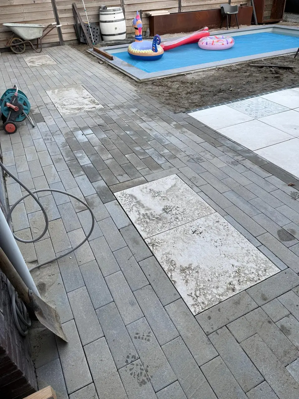 Tegelwerk in aanleg naast het zwembad