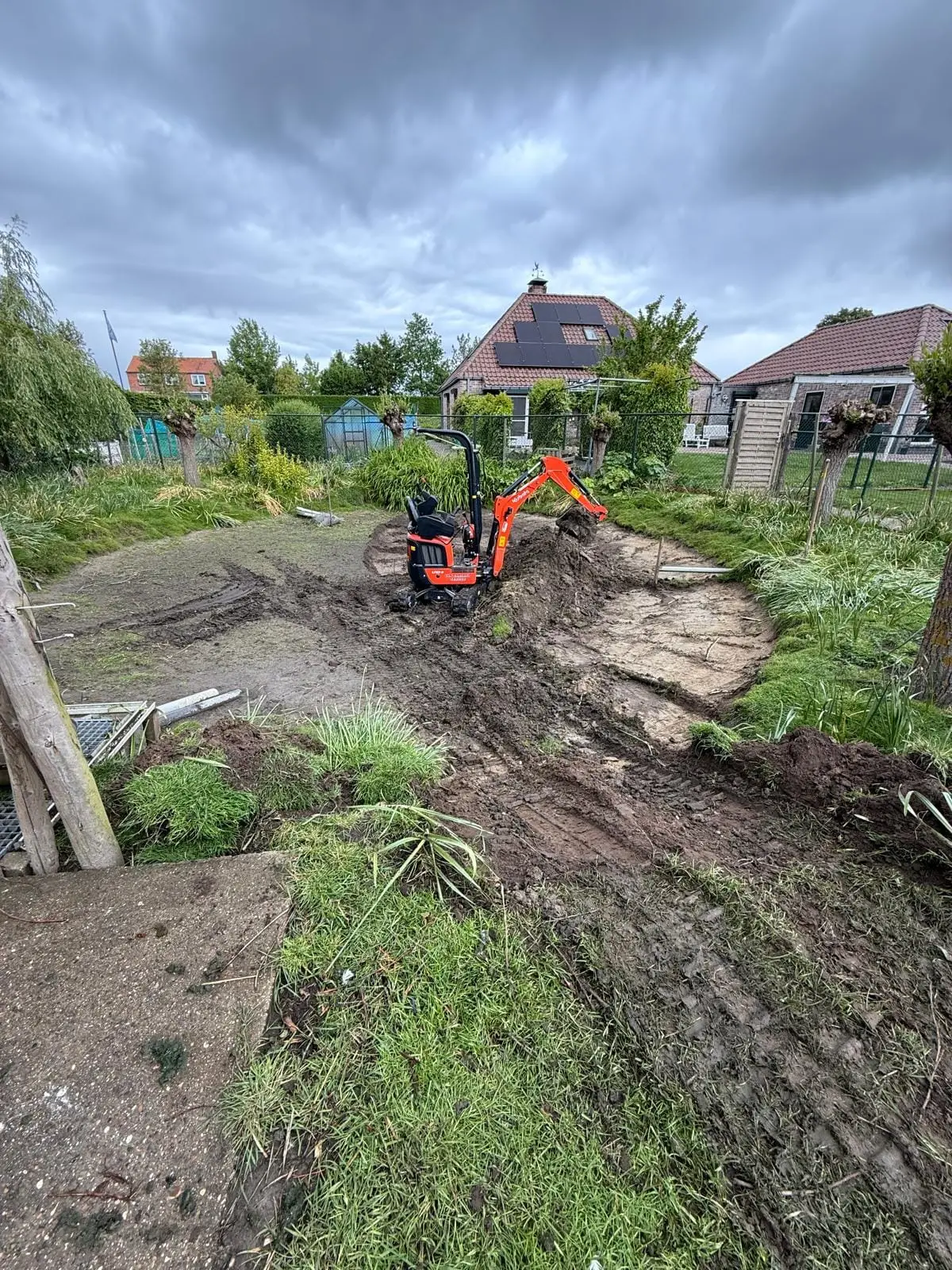 Minikraan graaft een put uit in een achtertuin