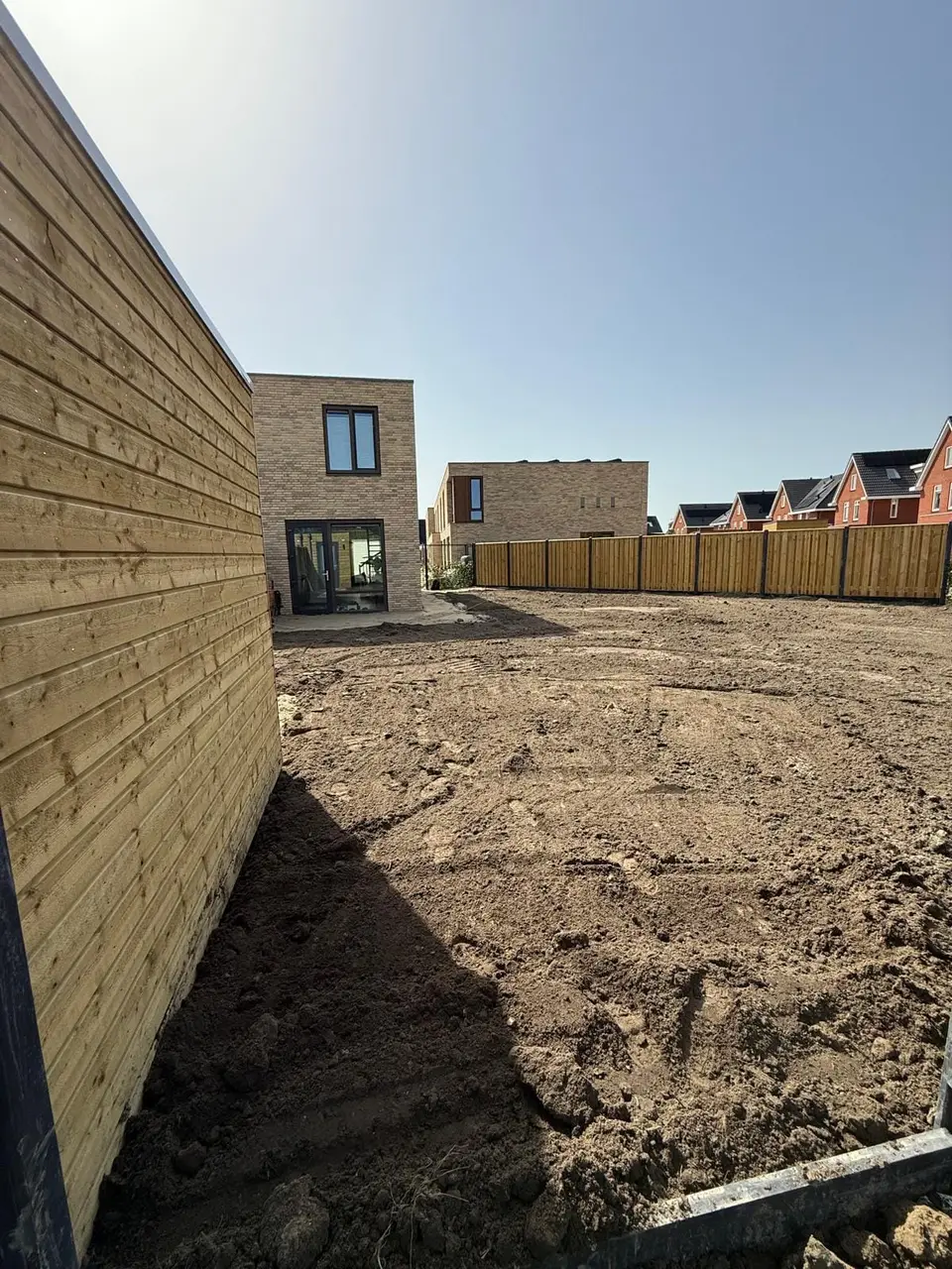 Kale bouwgrond achter een nieuwbouwwoning voor aanvang van het werk