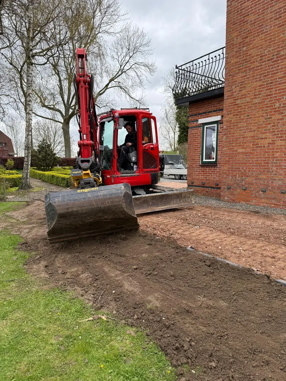 Aanvullen en afreien van de fundering rond de woning