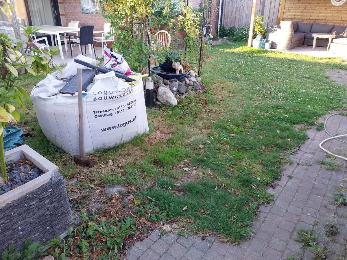 Minikraan tilt een big bag met afgegraven grond op de kipper