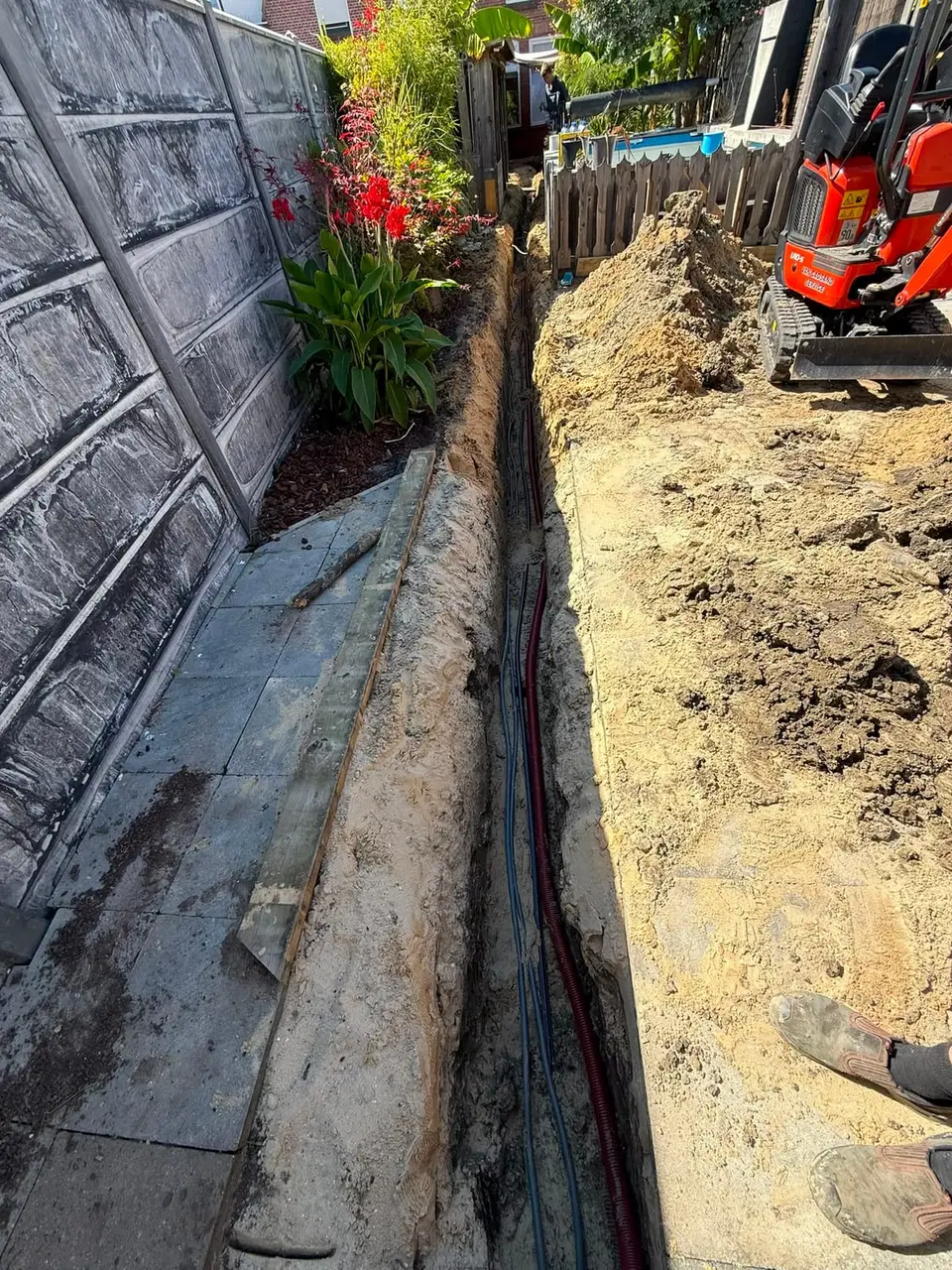 Kabel en mantelbuis in de gegraven sleuf