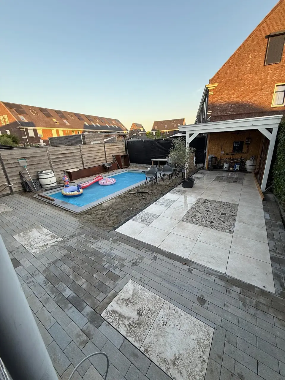 Afgewerkt terras rondom het zwembad bij avondlicht