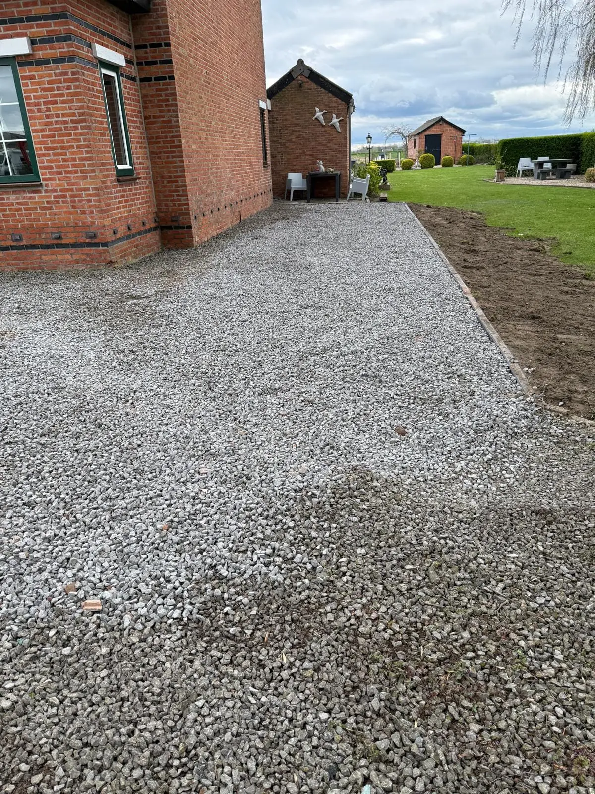 Afgewerkt grindpad met oprit naast een woning