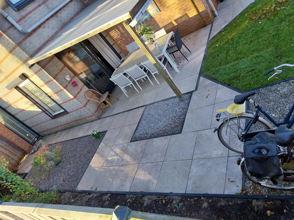 Terras met grindborder en zithoek onder de overkapping
