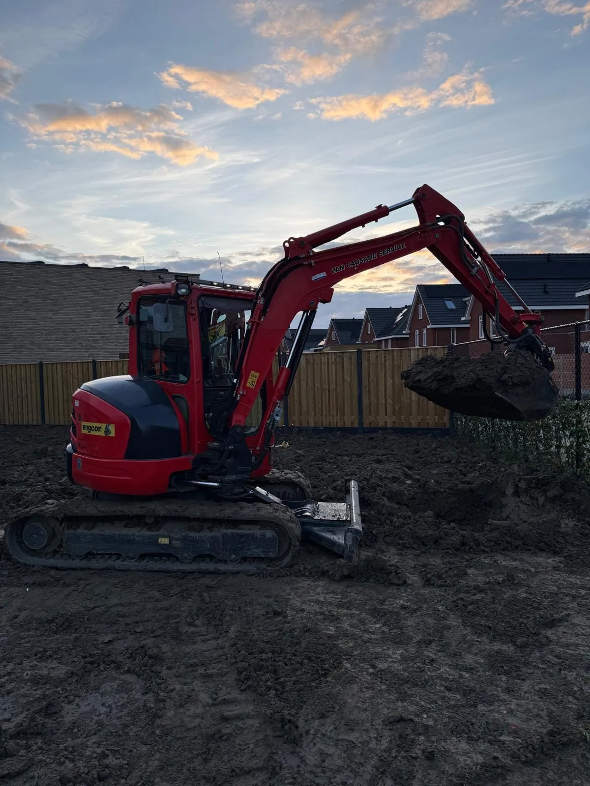 Minikraan van Van Cadsand Service aan het werk bij zonsondergang